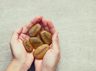 Hände tragen beschriftete Steine